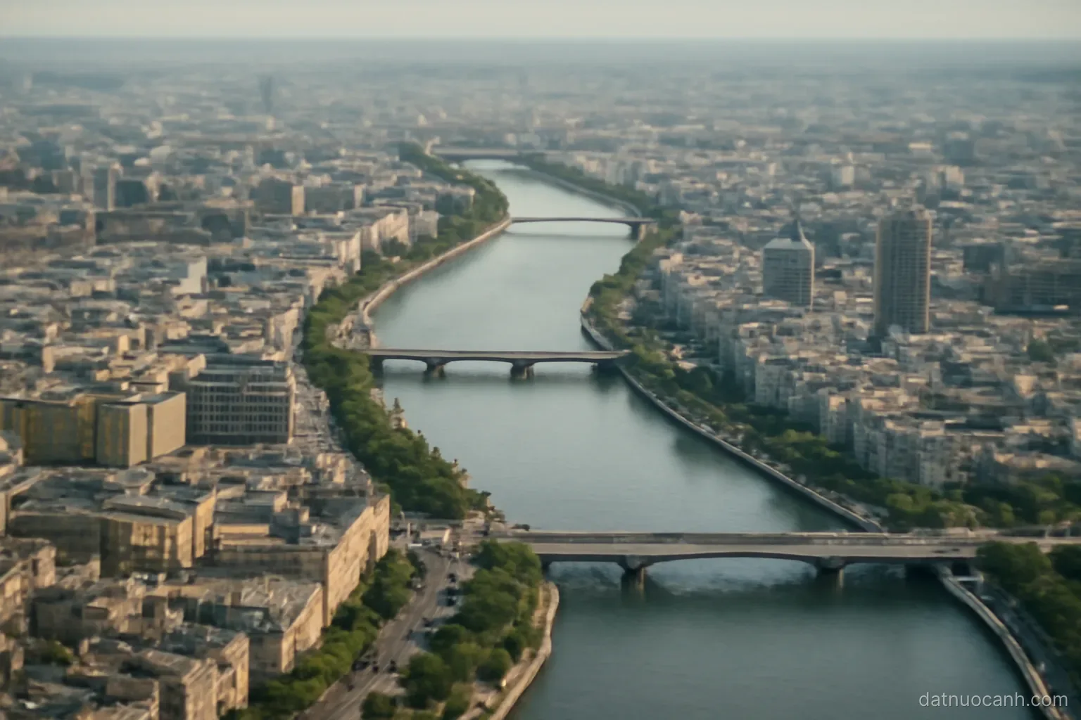 A wide river winding through a dense city with bridges, aerial view, no readable text