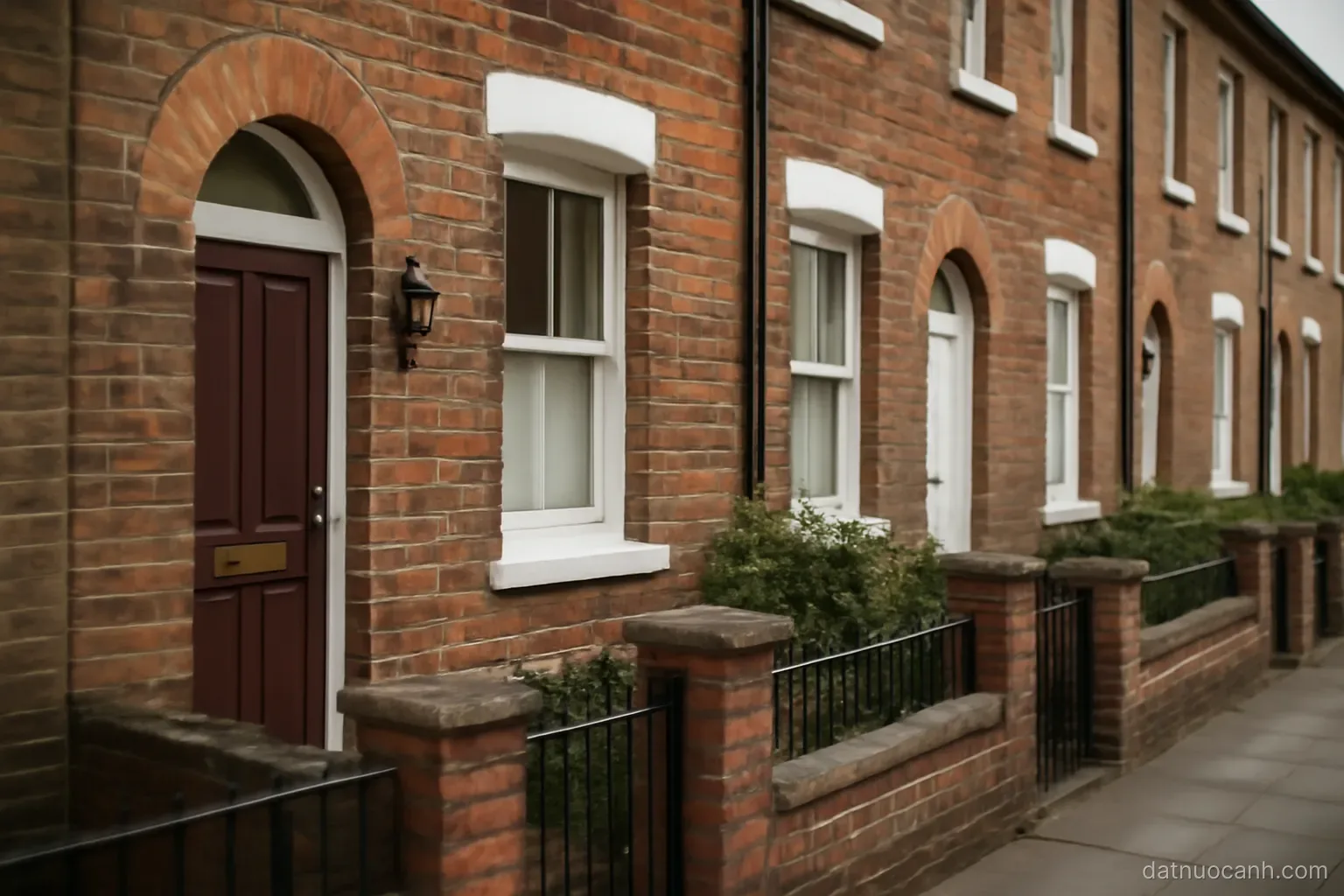A row of terraced houses with front doors and small gates, no readable text
